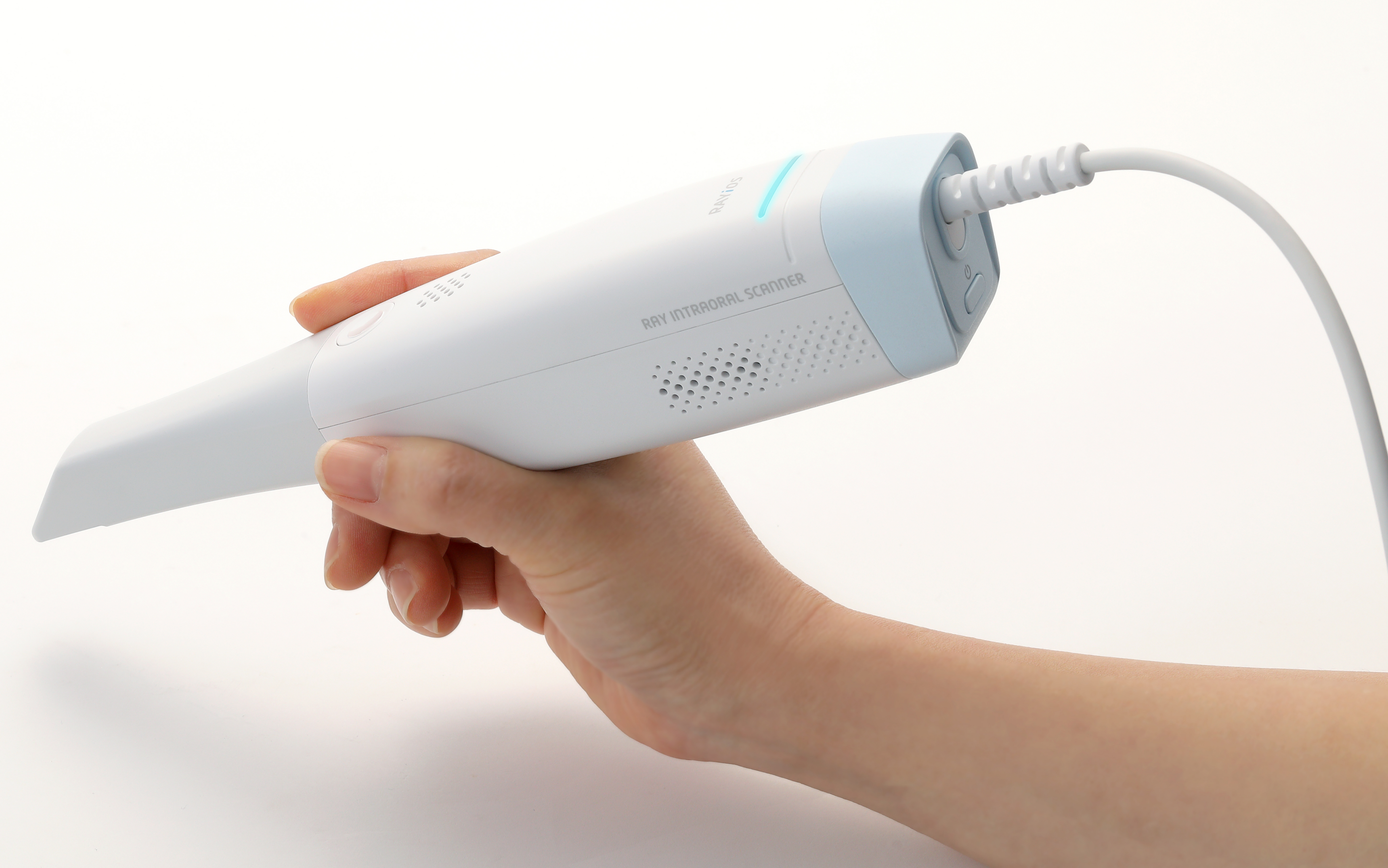 Hand holding a RAYiOS 10L intraoral scanner with connected cable during dental scanning use.