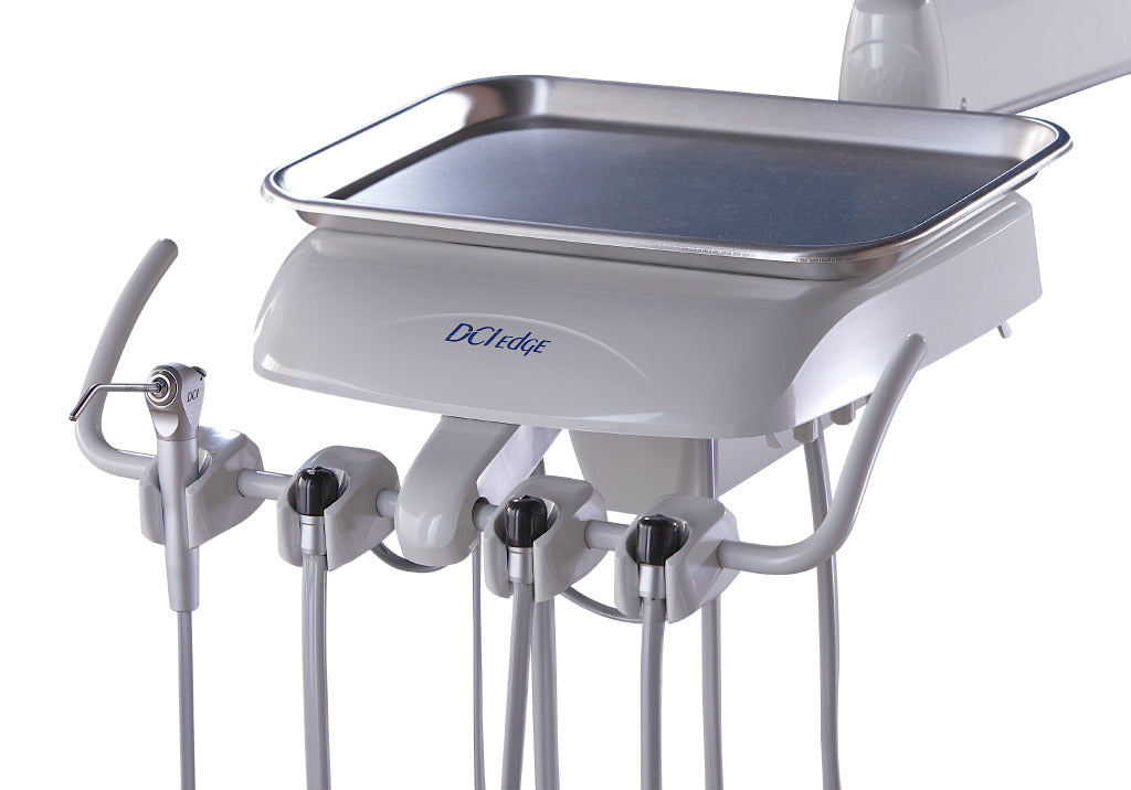 Dental delivery unit with instrument holders, handpieces and stainless steel tray for dental procedures.