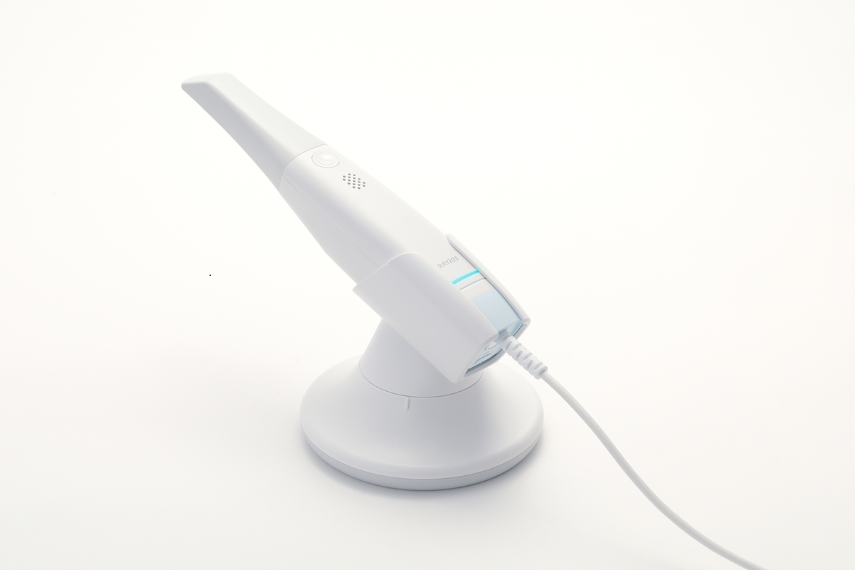 RAYiOS 10L intraoral scanner on a charging stand with connected cable on a white background.